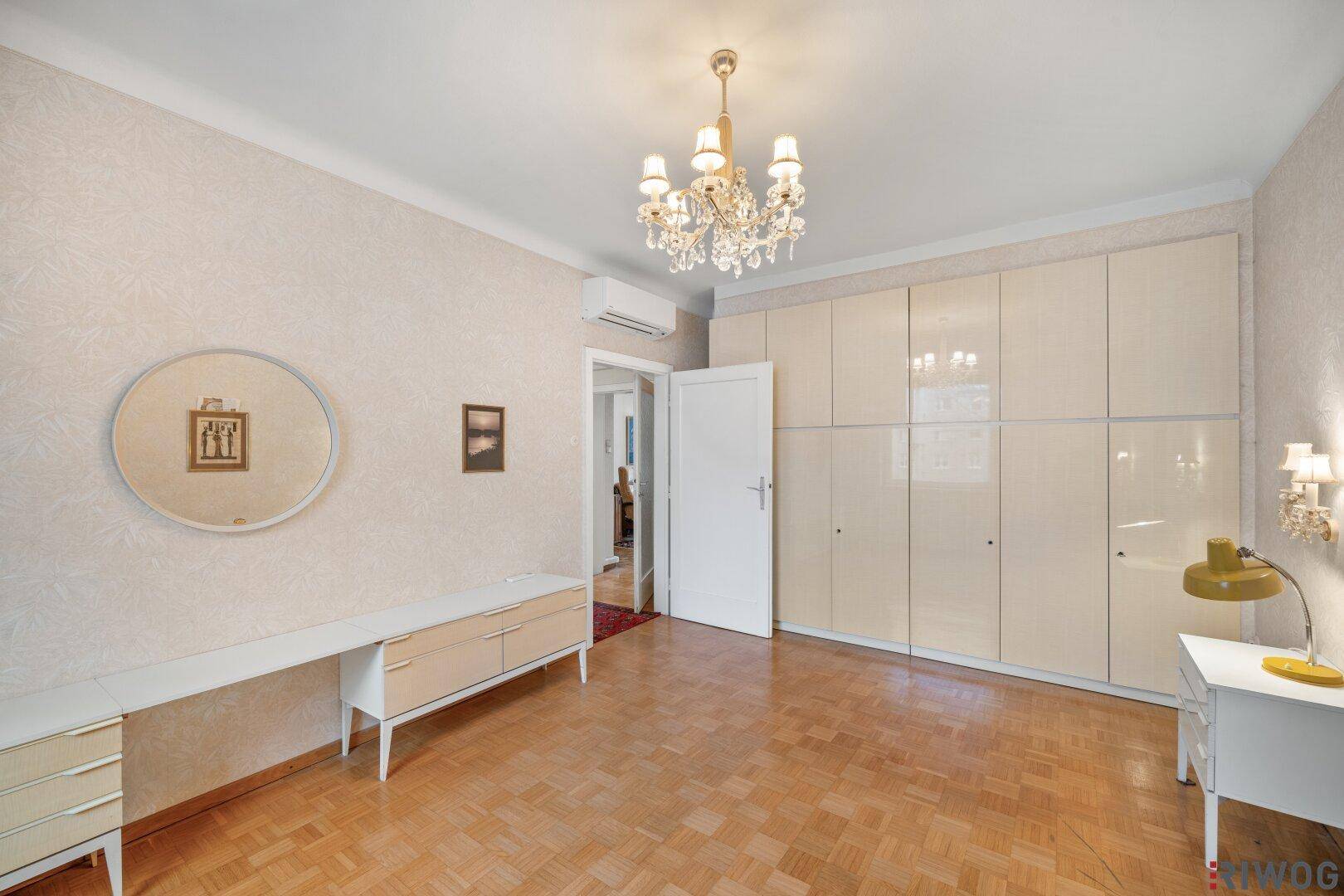 Geräumiges Schlafzimmer mit Parkettboden, Einbauschränken und Schminktisch.