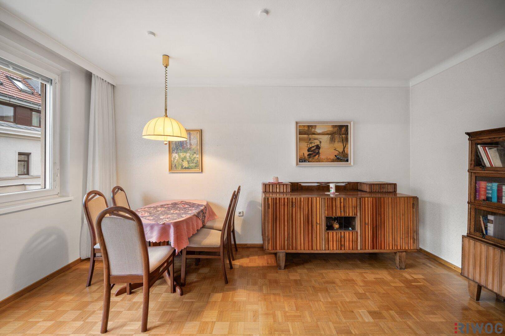 Esszimmer mit Parkettboden, Holzanrichte und traditioneller Einrichtung.
