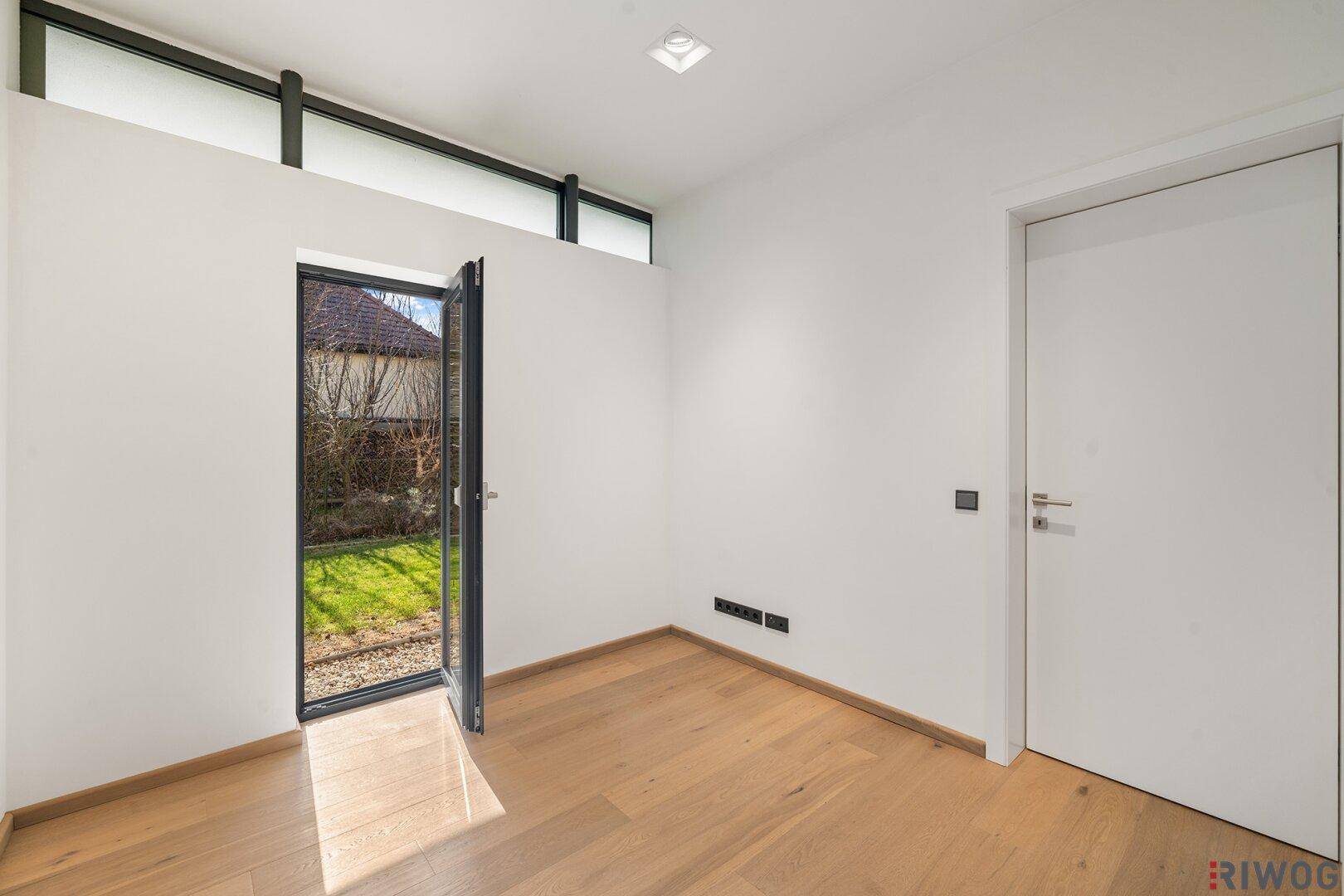 Helles Schlafzimmer mit Holzboden und direktem Zugang zum Gartenbereich.