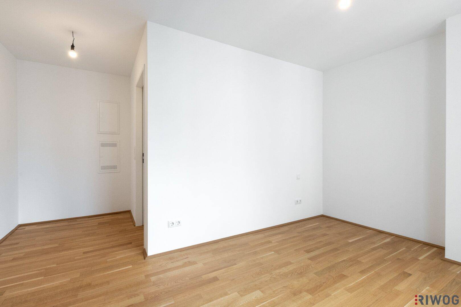 Leeres Schlafzimmer mit Parkettboden und weißen Wänden, bereit zur individuellen Gestaltung.