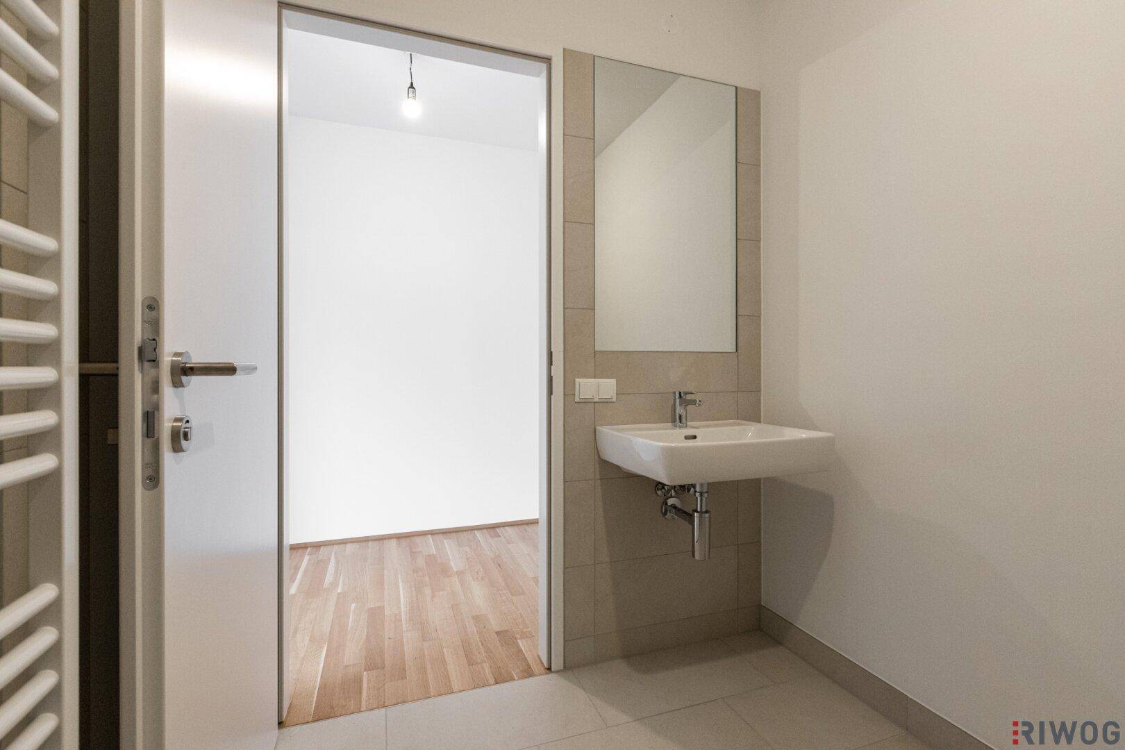 Helles Badezimmer mit modernem Waschbecken und großem Spiegel.