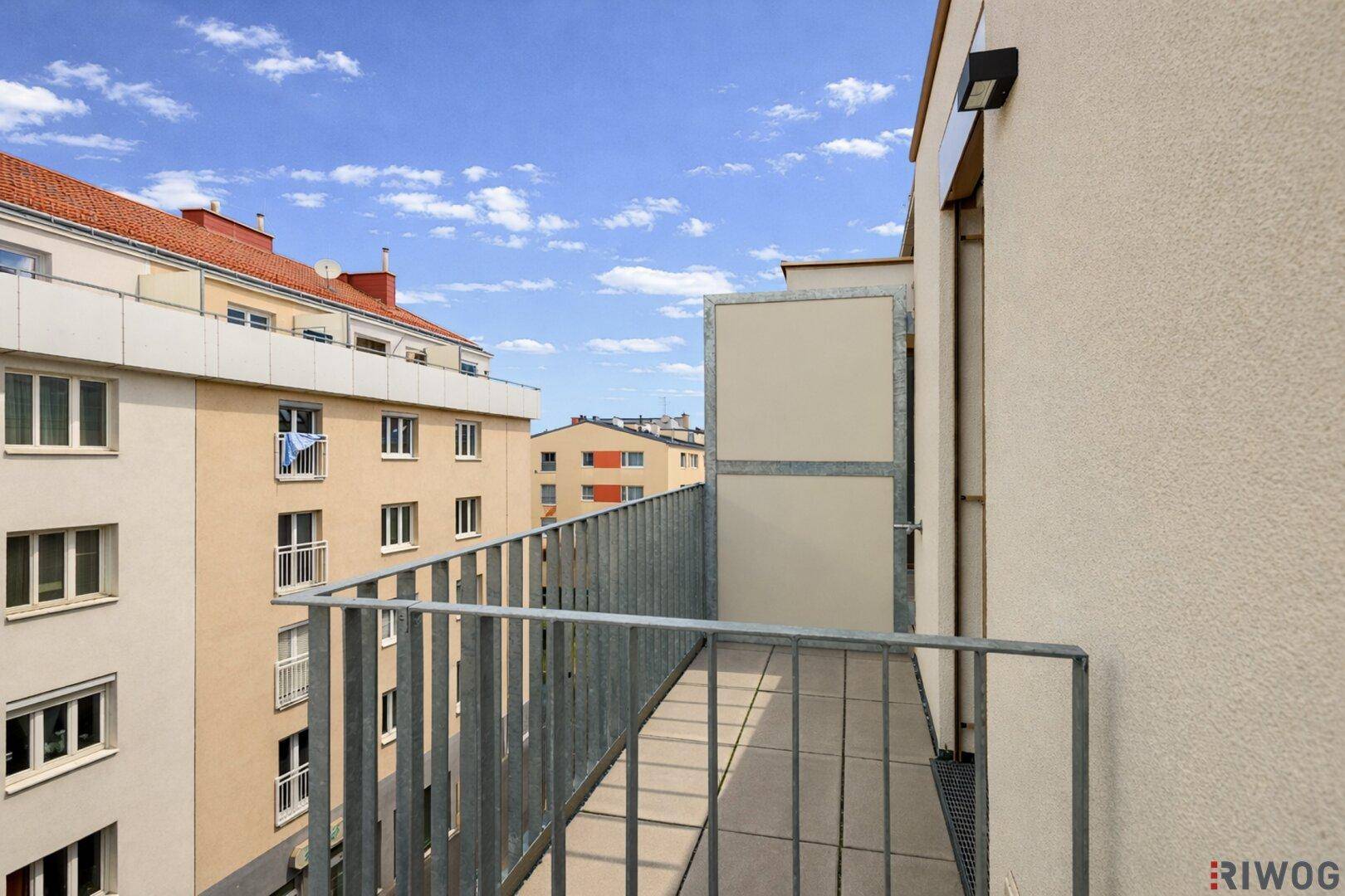 Kleiner Balkon mit Metallgeländer und Blick auf die umliegenden Gebäude, ideal für frische Luft.