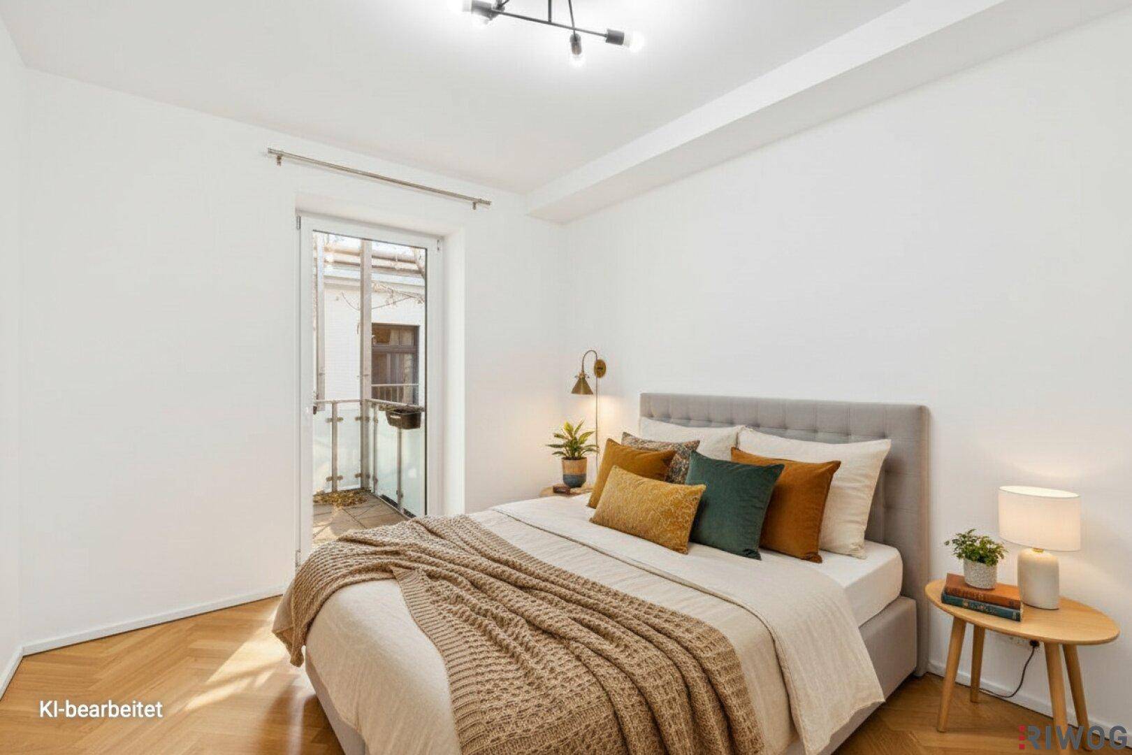 Helles Schlafzimmer mit Parkettboden, modernem Bett und Zugang zu einem kleinen Balkon.