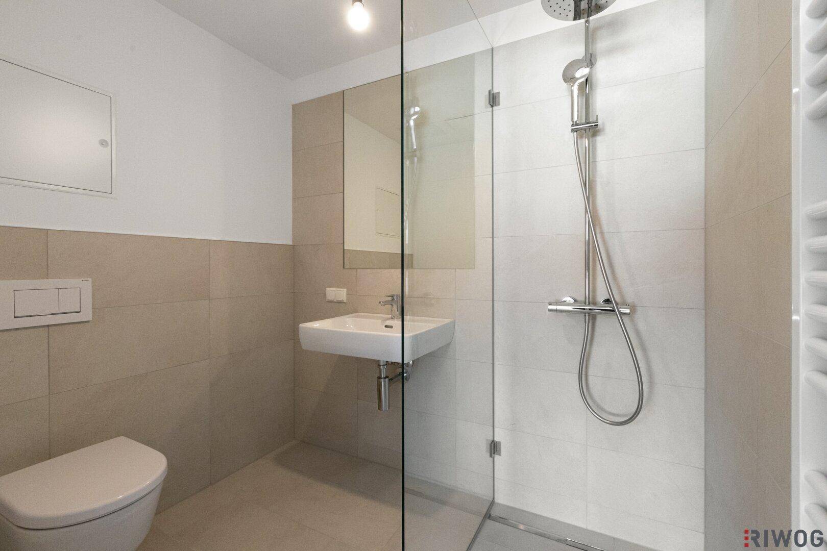 Modernes Badezimmer mit ebenerdiger Dusche, Wand-WC und beigefarbenen Fliesen.