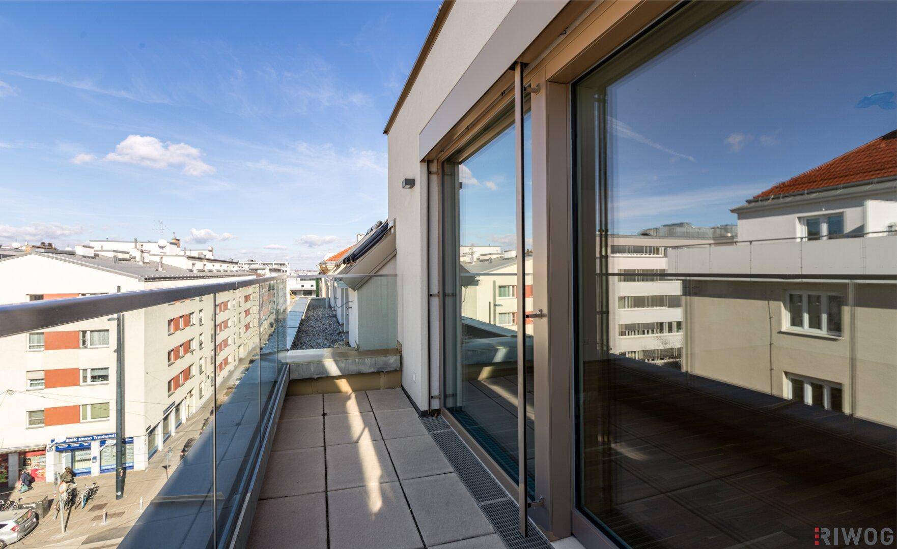 Geräumiger Balkon mit Fliesenboden und moderner Glasbrüstung, ideal für sonnige Tage.