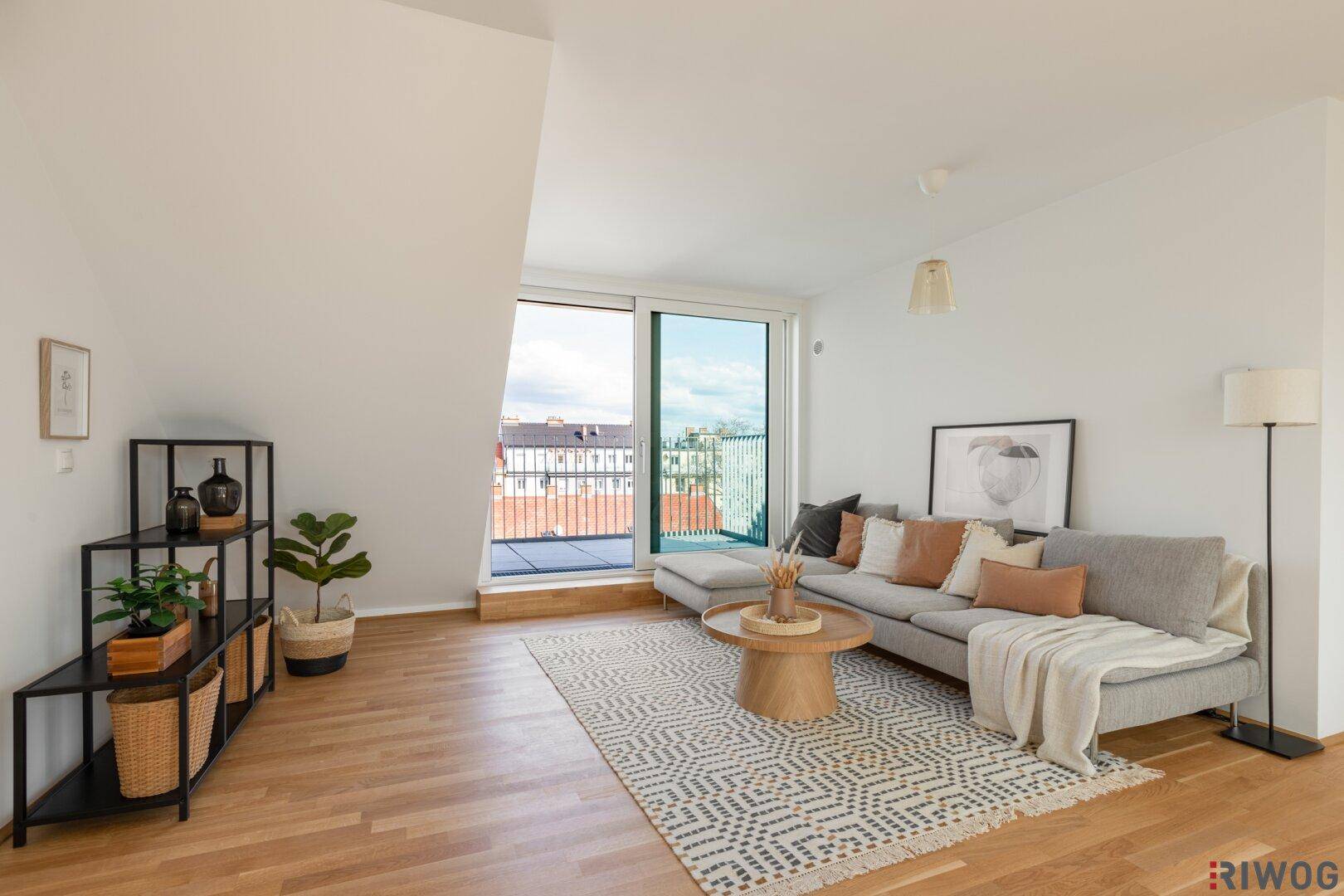 Gemütliches Wohnzimmer mit Holzboden, modernem Sofa und Zugang zu einem Balkon.
