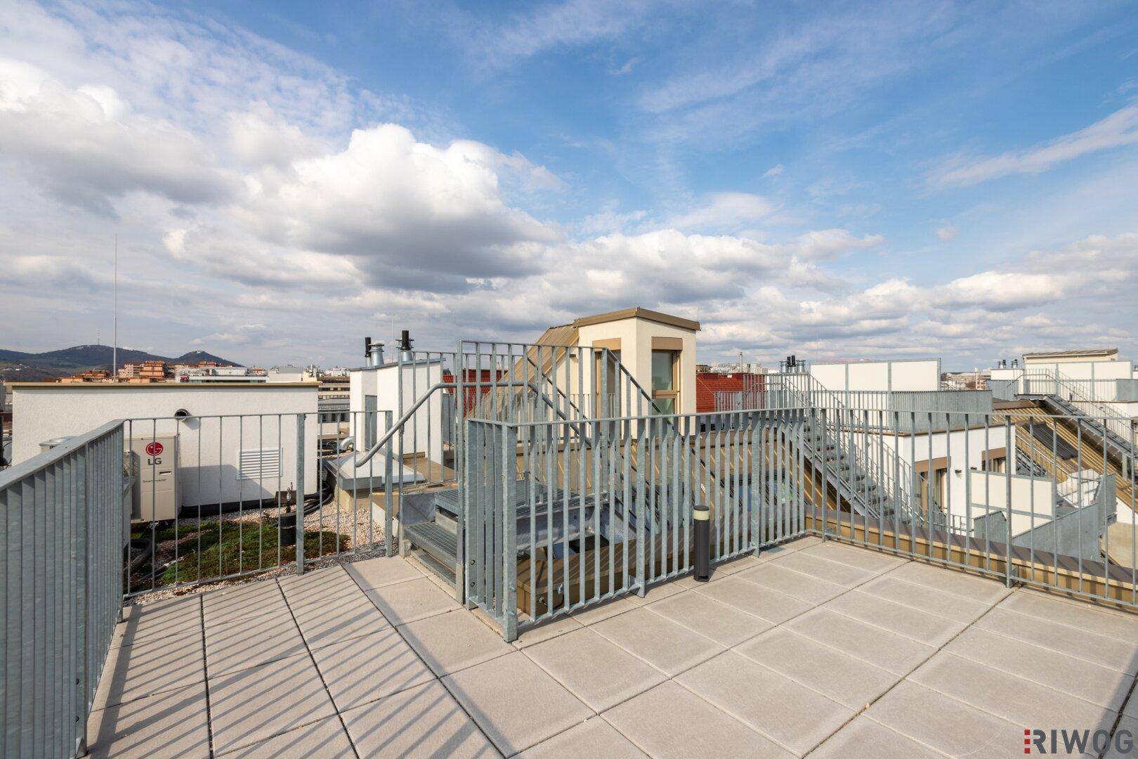 Dachterrasse mit Zugang zu weiteren Ebenen über Außentreppen und Blick auf die Umgebung.