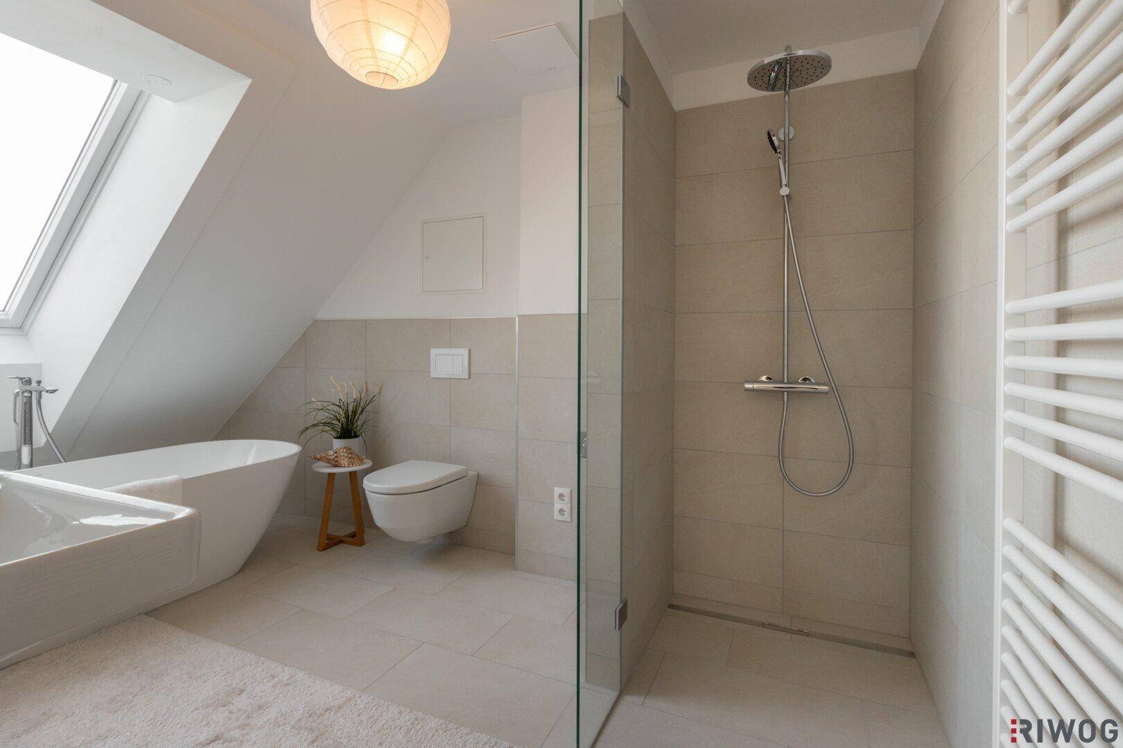Elegantes Badezimmer mit ebenerdiger Dusche, Wand-WC und beheiztem Handtuchhalter.