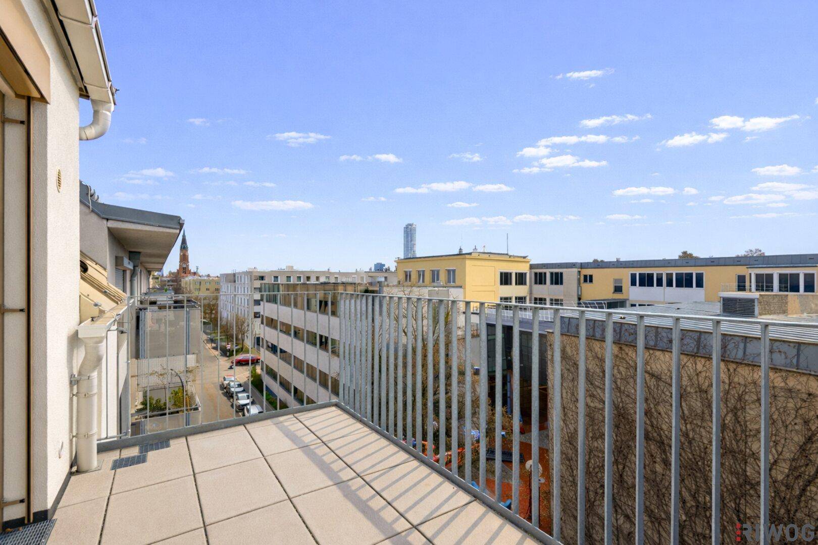 Geräumiger Balkon mit Fliesenboden und weitem Blick über die Stadt.