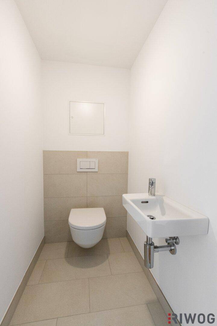 Gäste-WC mit wandhängender Toilette und kleinem Waschbecken.
