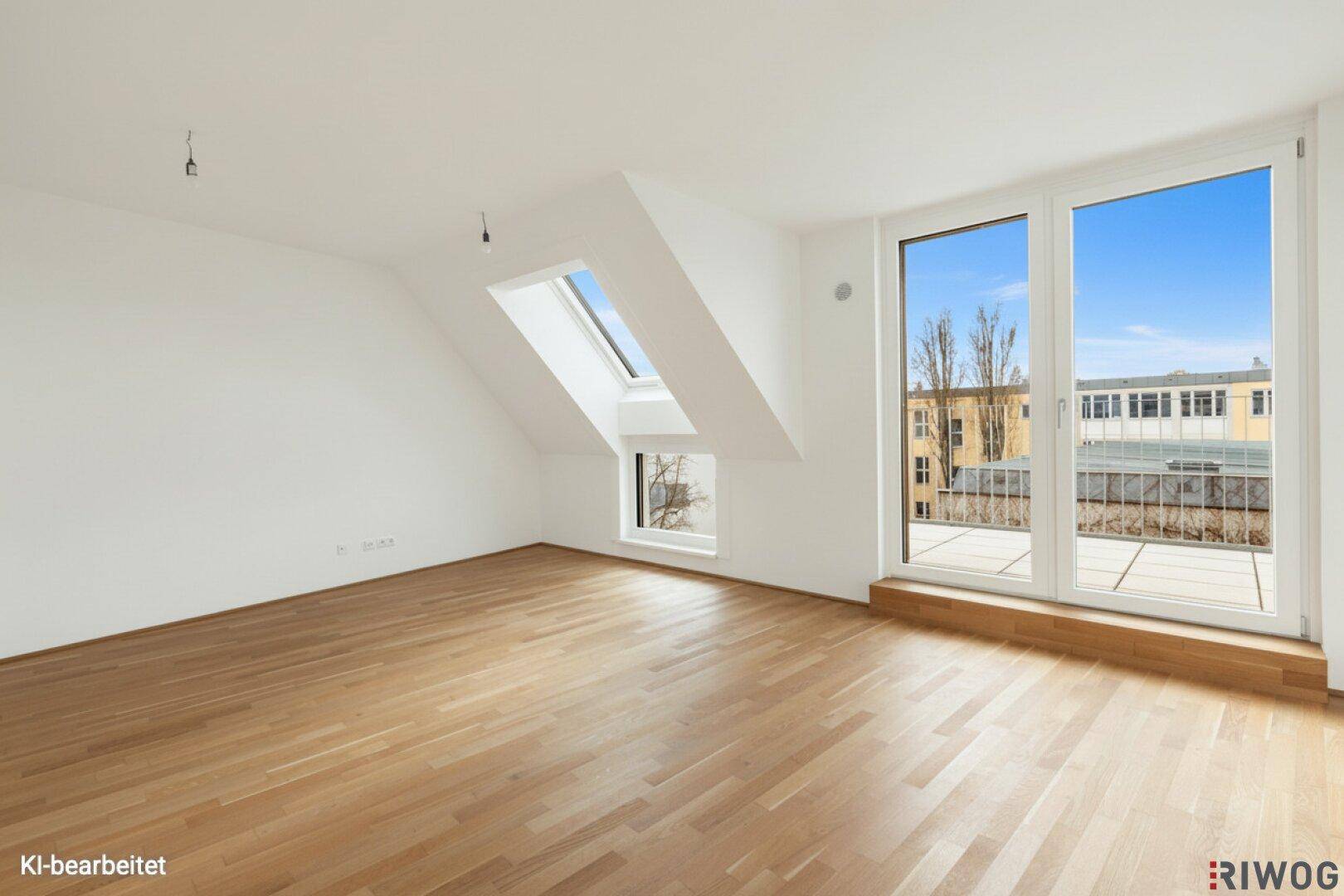 Heller Raum mit Parkettboden, Dachschrägen und Zugang zum Balkon.