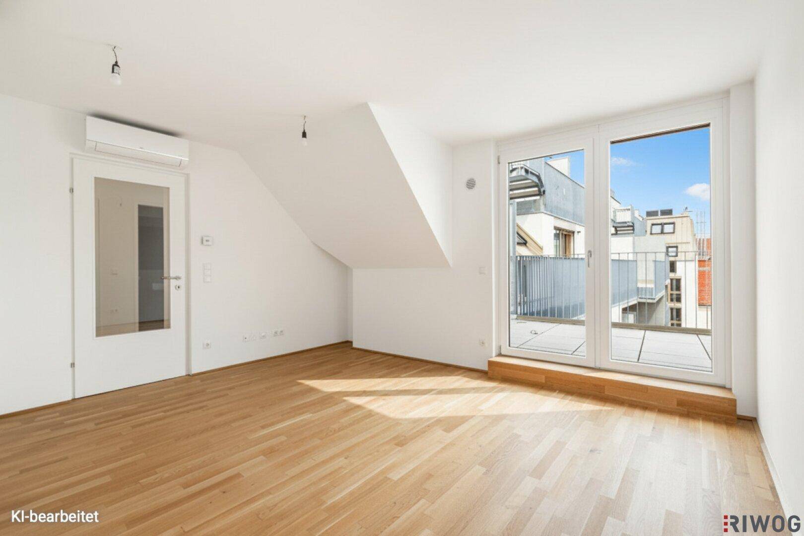 Helles Wohnzimmer mit Parkettboden, Dachschräge und Zugang zum Balkon.