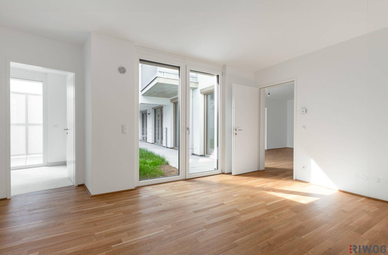 Geräumiges, helles Zimmer mit Parkettboden und großen Fenstern zum Innenhof.