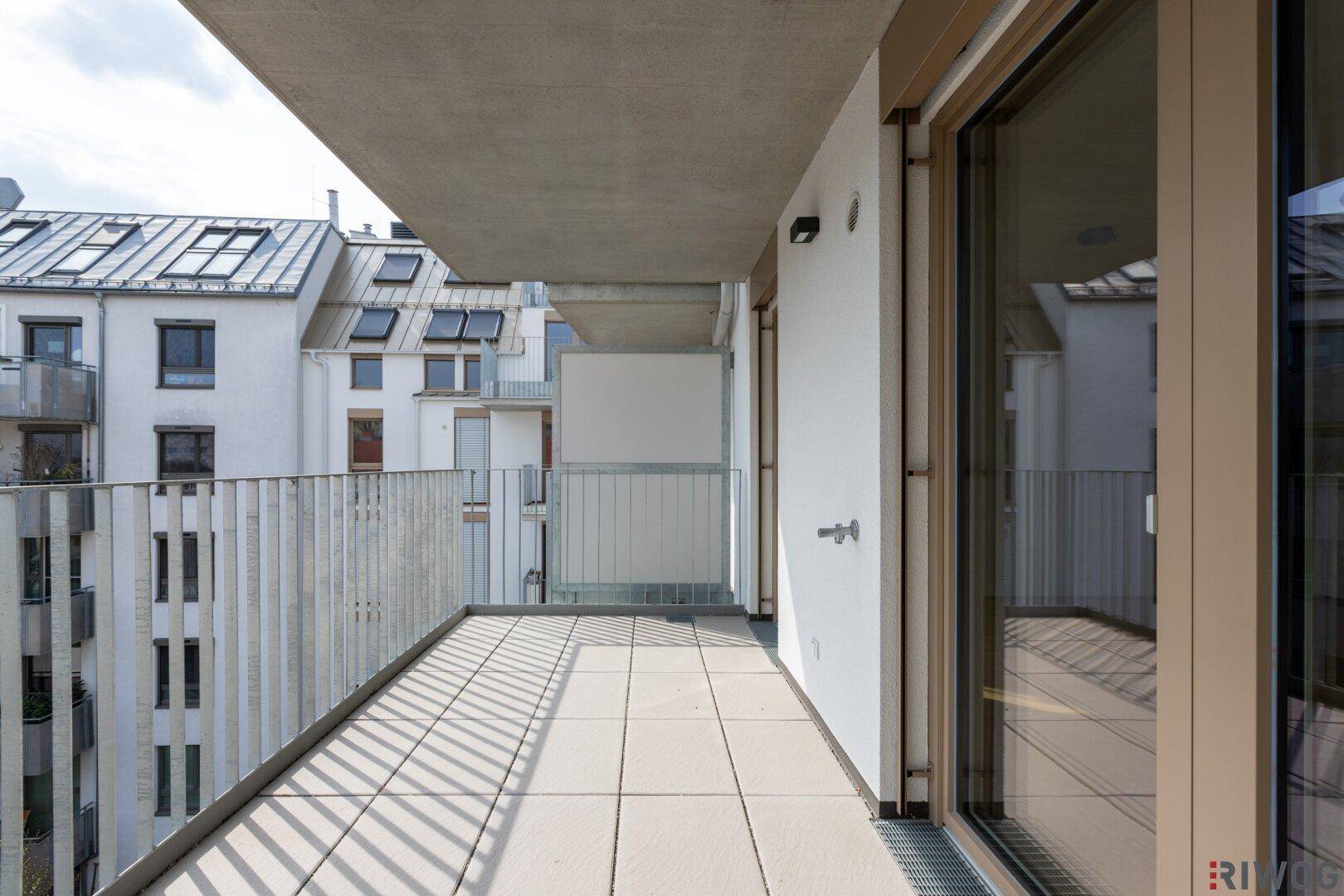 Langer Balkon mit Fliesenboden und moderner Metallbrüstung.