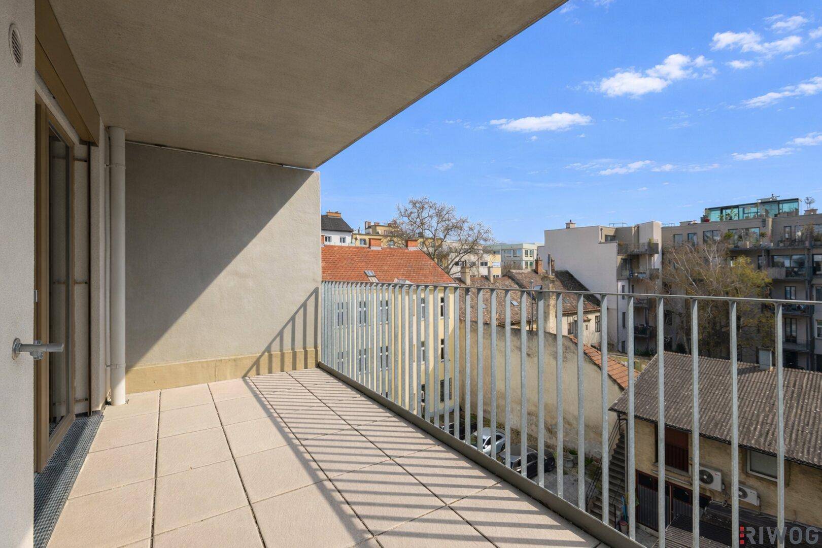 Geräumiger Balkon mit Fliesenboden und weitem Blick über die Stadt.