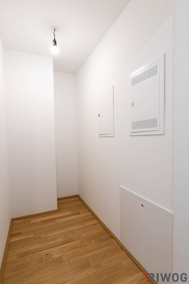 Schmaler Flur mit Parkettboden und Zugang zu verschiedenen Räumen.