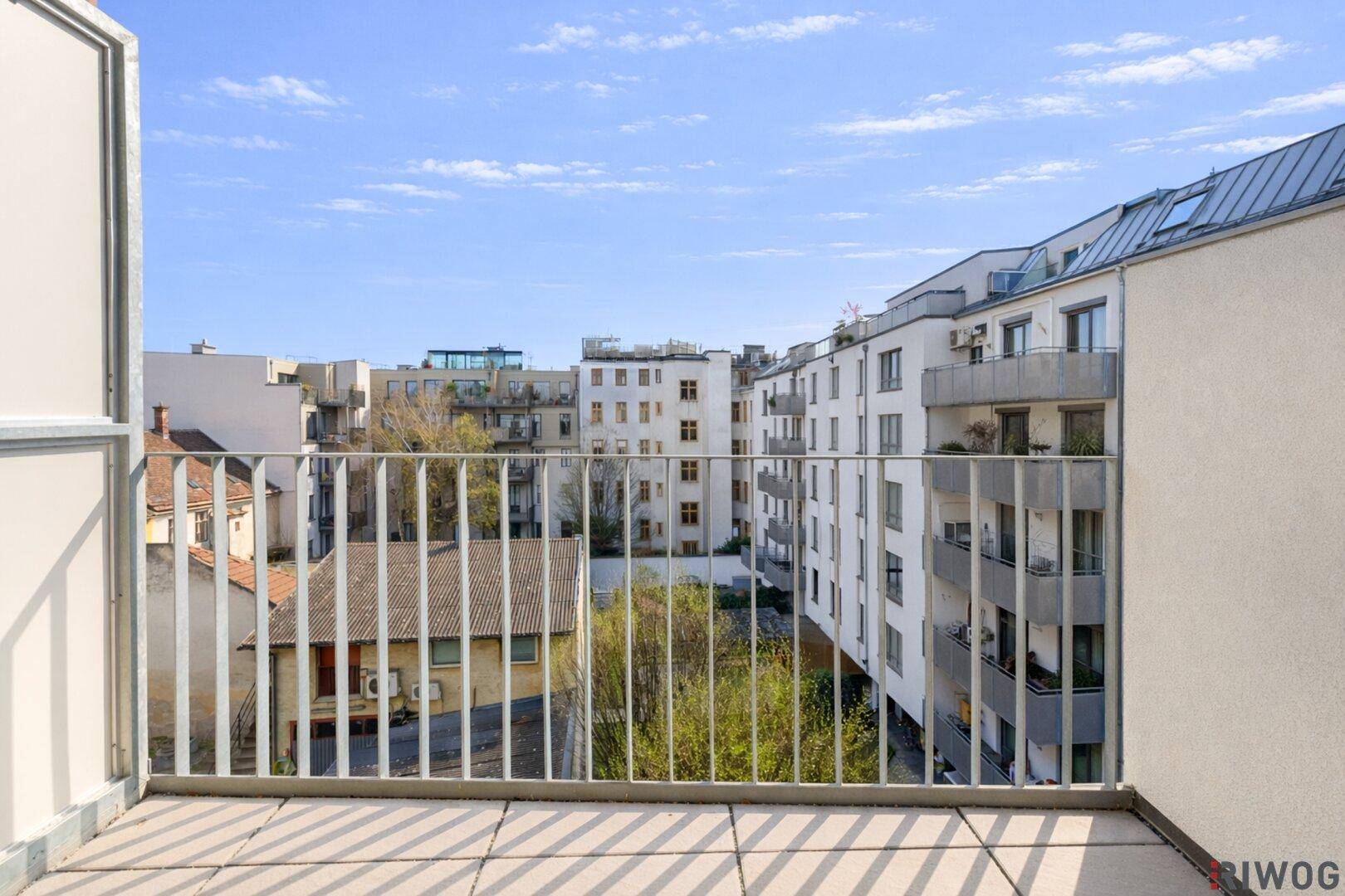 Balkon mit Weitblick über die Dächer der Stadt und die umliegende moderne Architektur.