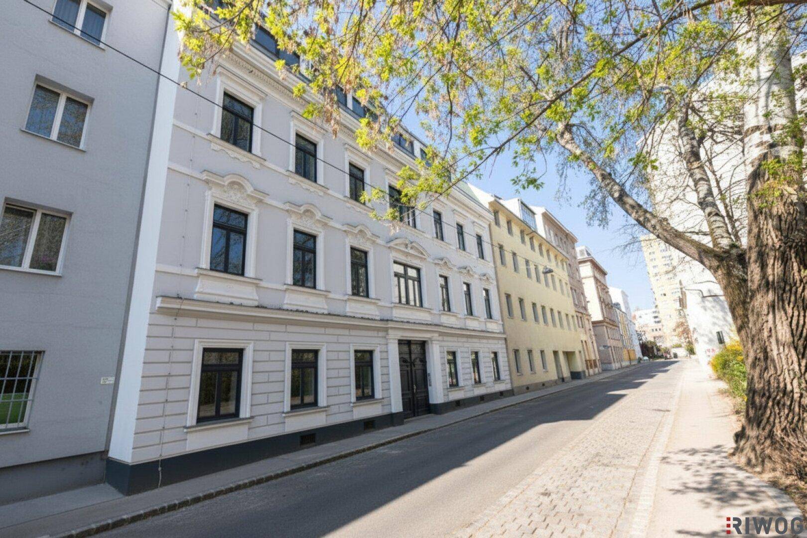 Historisches Gebäude mit klassischer Fassade an einer ruhigen Stadtstraße.