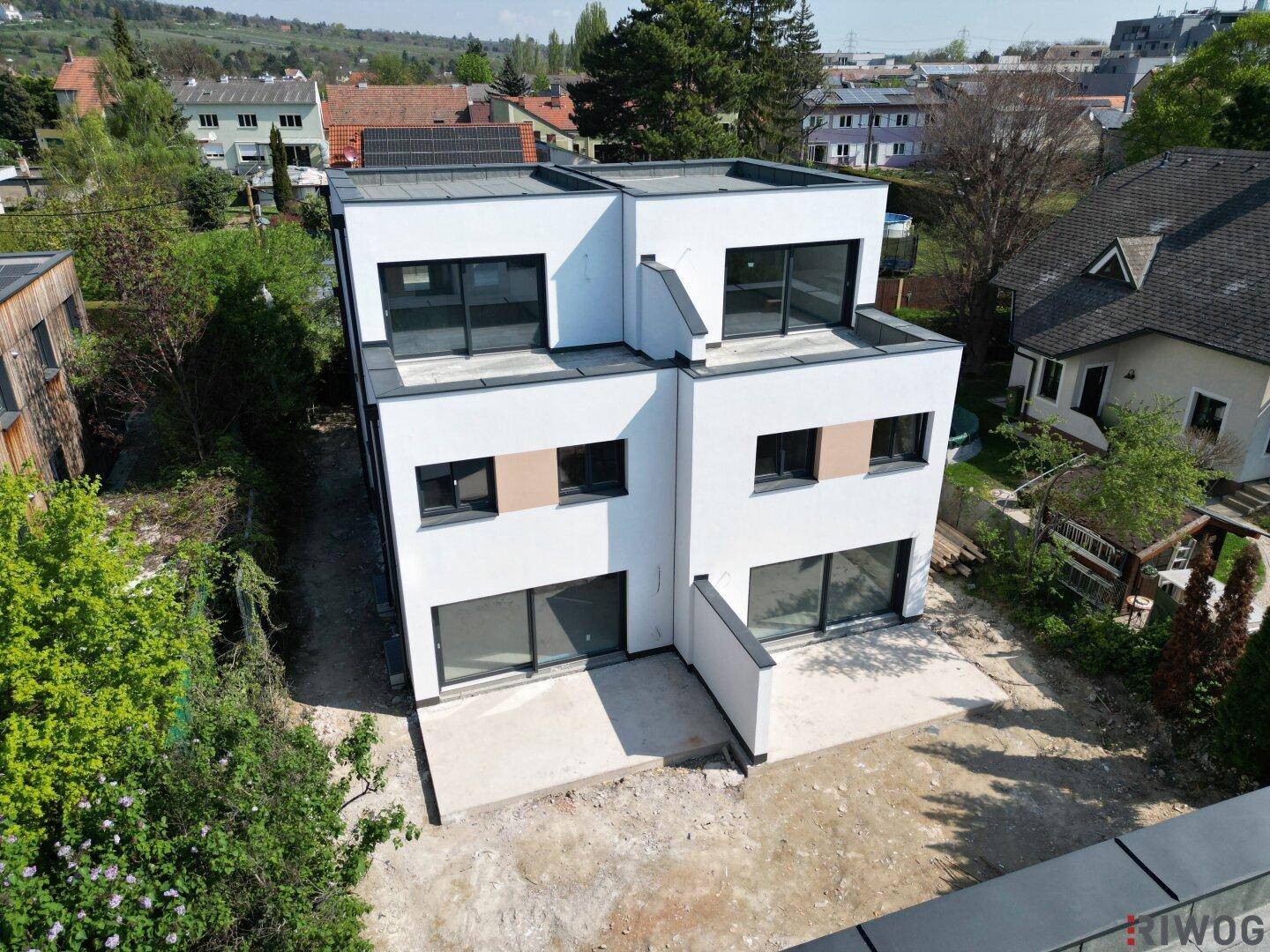 Moderne Doppelhaushälfte mit großen Fensterfronten und Flachdach in sonniger Lage, bereit zum Bezug.