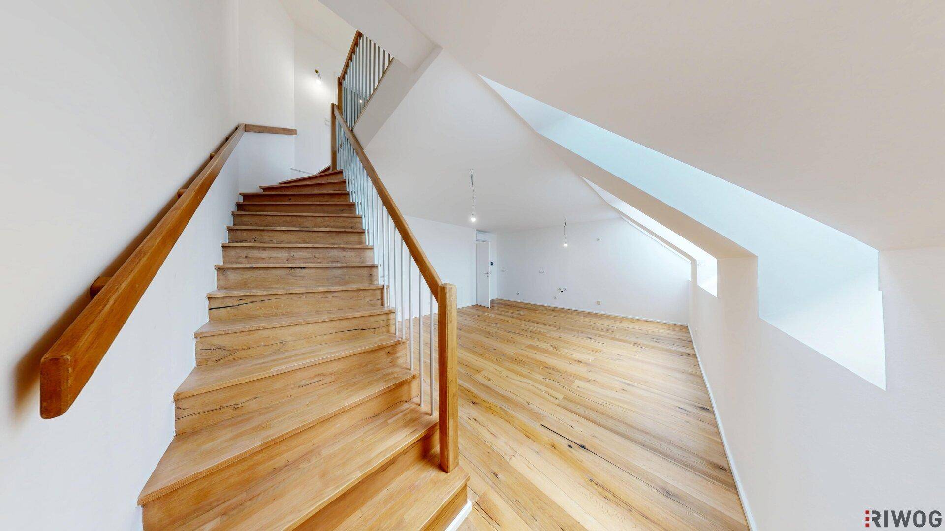 Holztreppe mit Geländer, die verschiedene Ebenen der Wohnung verbindet.