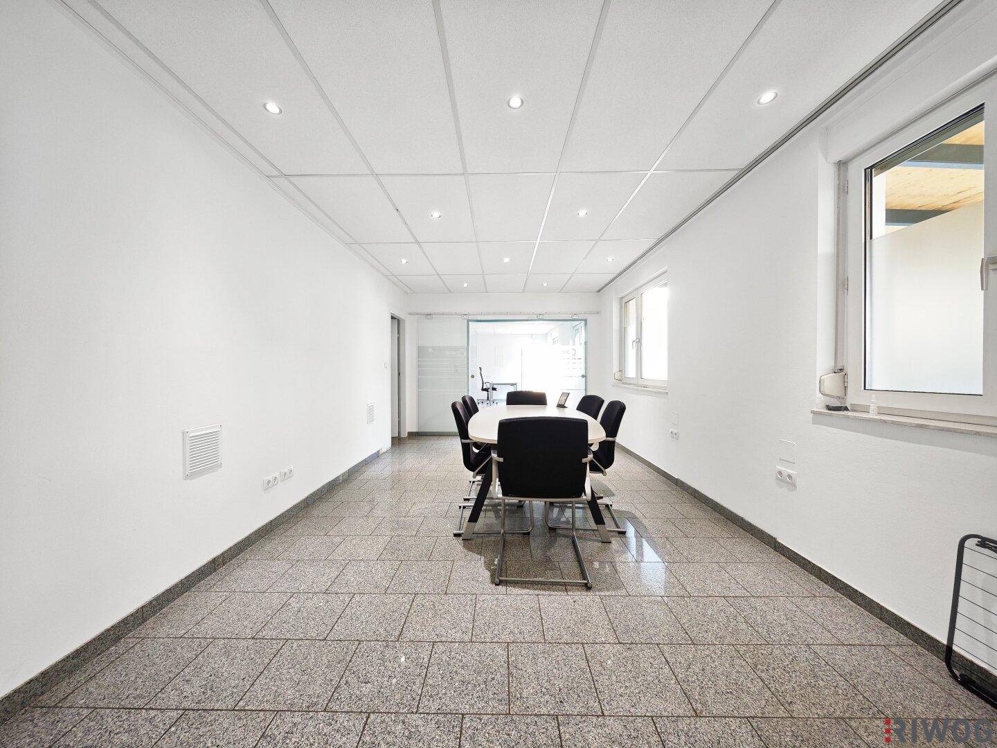 Besprechungsraum mit Granitfliesenboden, abgehängter Decke und integrierten Strahlern.