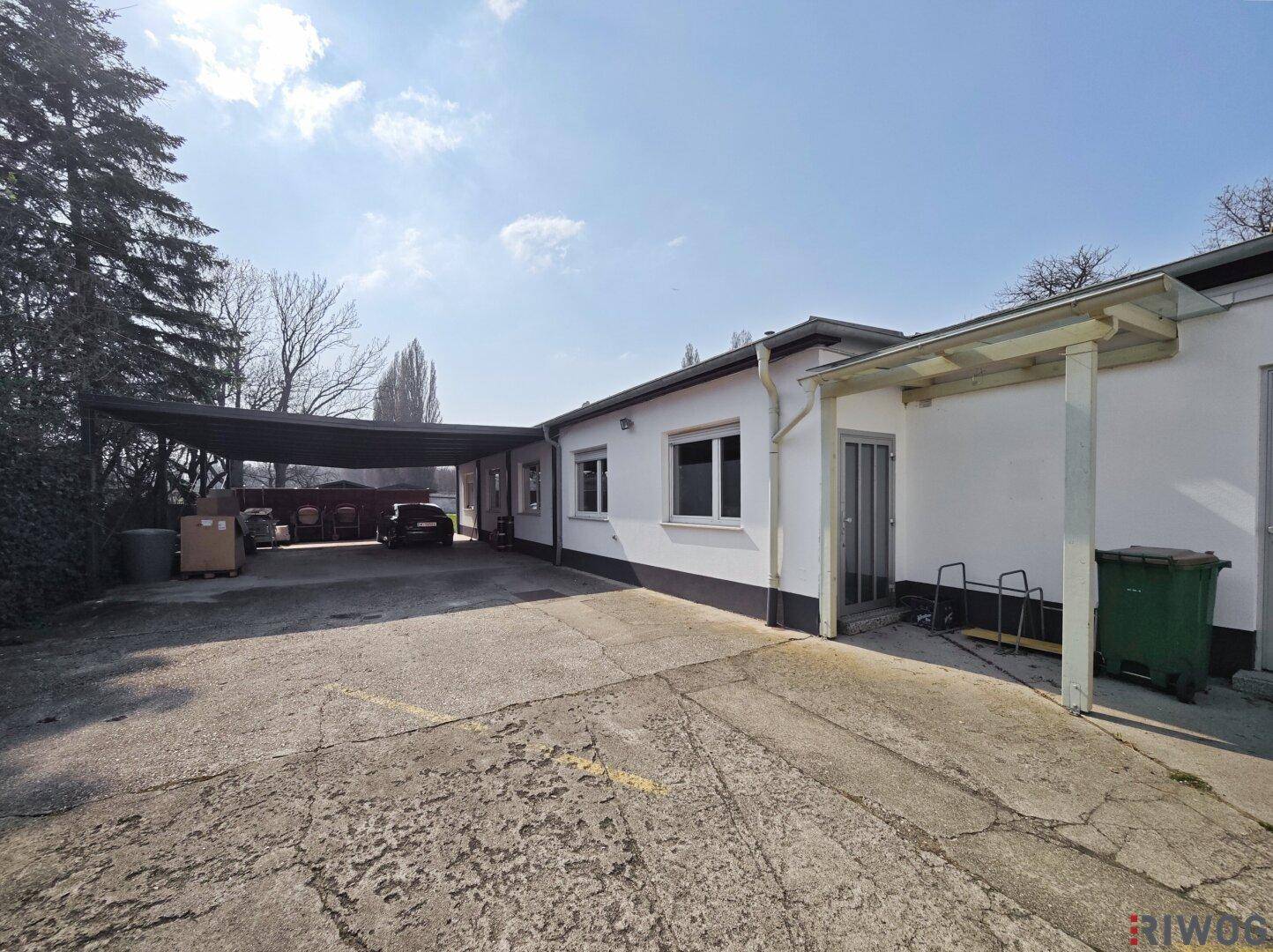Außenansicht der Gebäude mit überdachtem Parkplatz und Zufahrt.