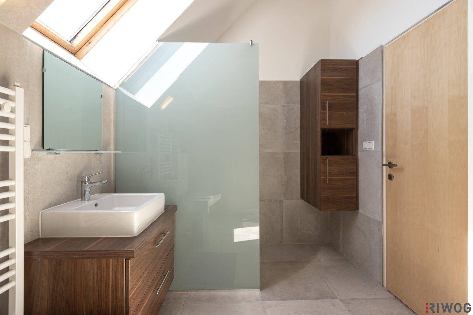 Modernes Badezimmer mit Dachfenster, begehbarer Dusche und Holzwaschtisch.