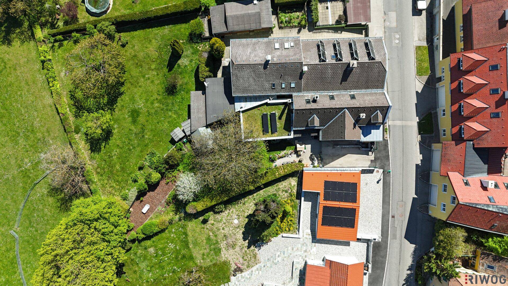 Vogelperspektive eines Wohngebiets mit viel Grün und Photovoltaikanlagen auf den Dächern.