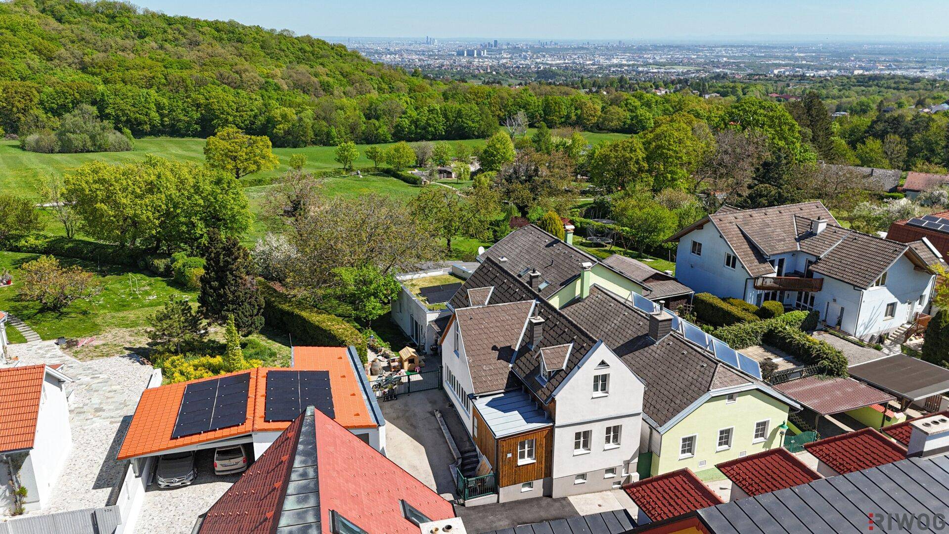 Weitläufige Luftaufnahme eines Wohngebiets mit Blick auf die Stadt in der Ferne.