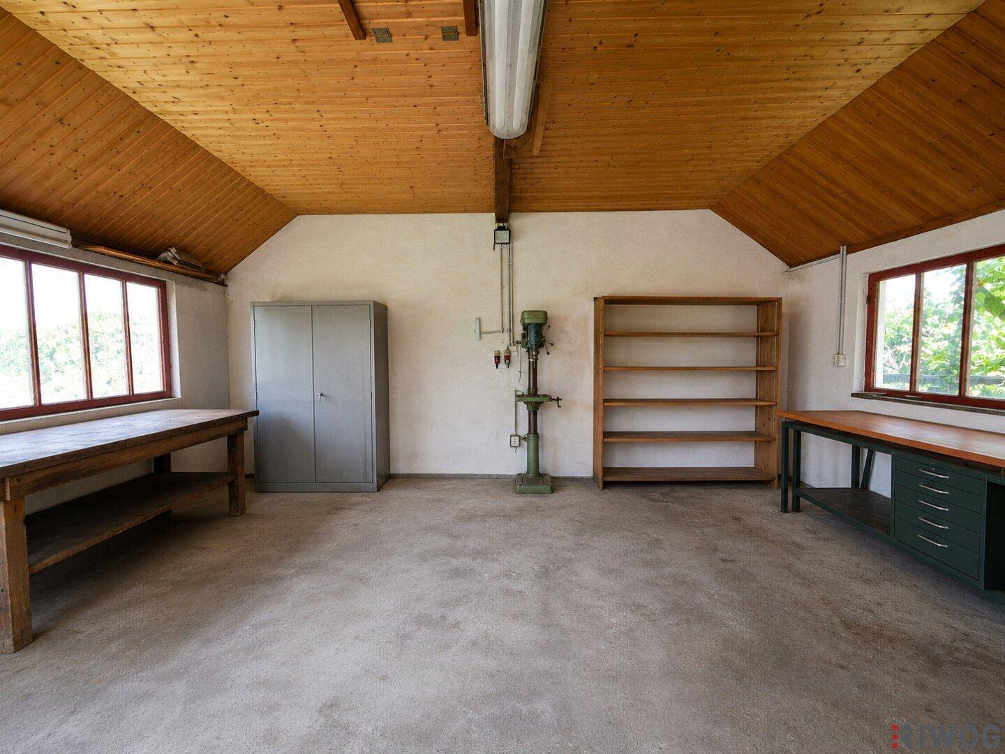 Leere Werkstatt mit Holzdecke und Betonboden, bereit für neue Projekte und Ausstattungen.