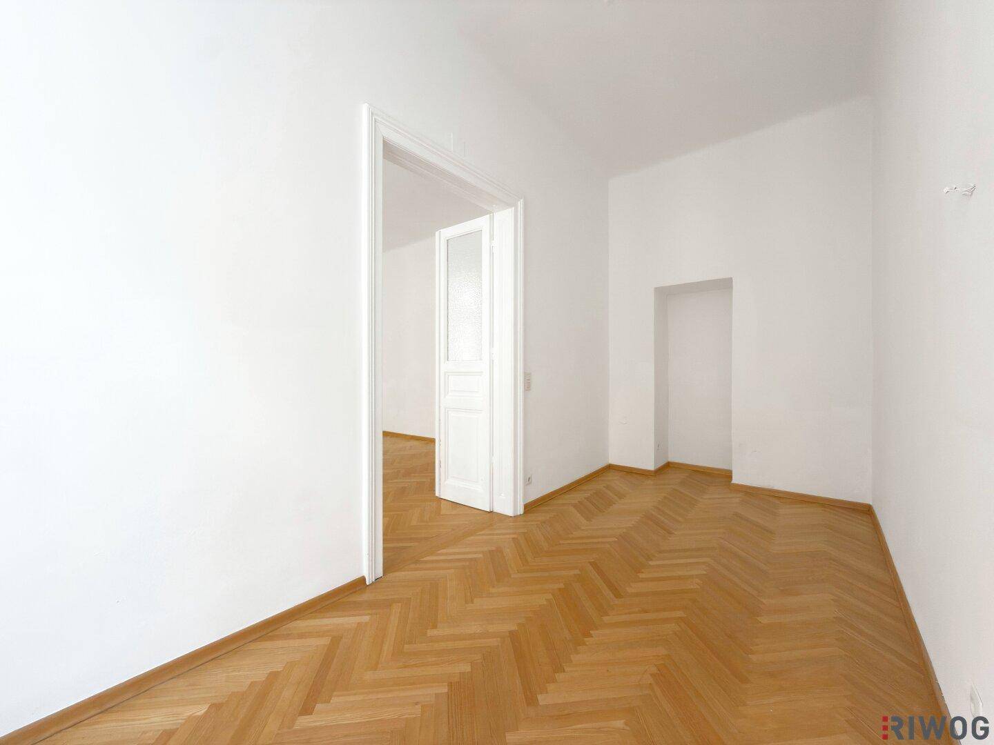 Heller Raum mit Fischgrätparkett und einer Nische, ideal für individuelle Einrichtungsideen.