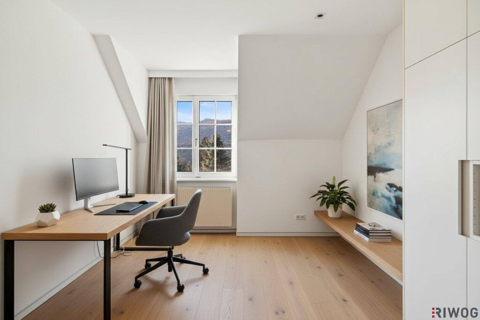 Helles Büro mit Holzboden, Dachschrägen, Fenster mit Bergblick und integriertem Schrank.