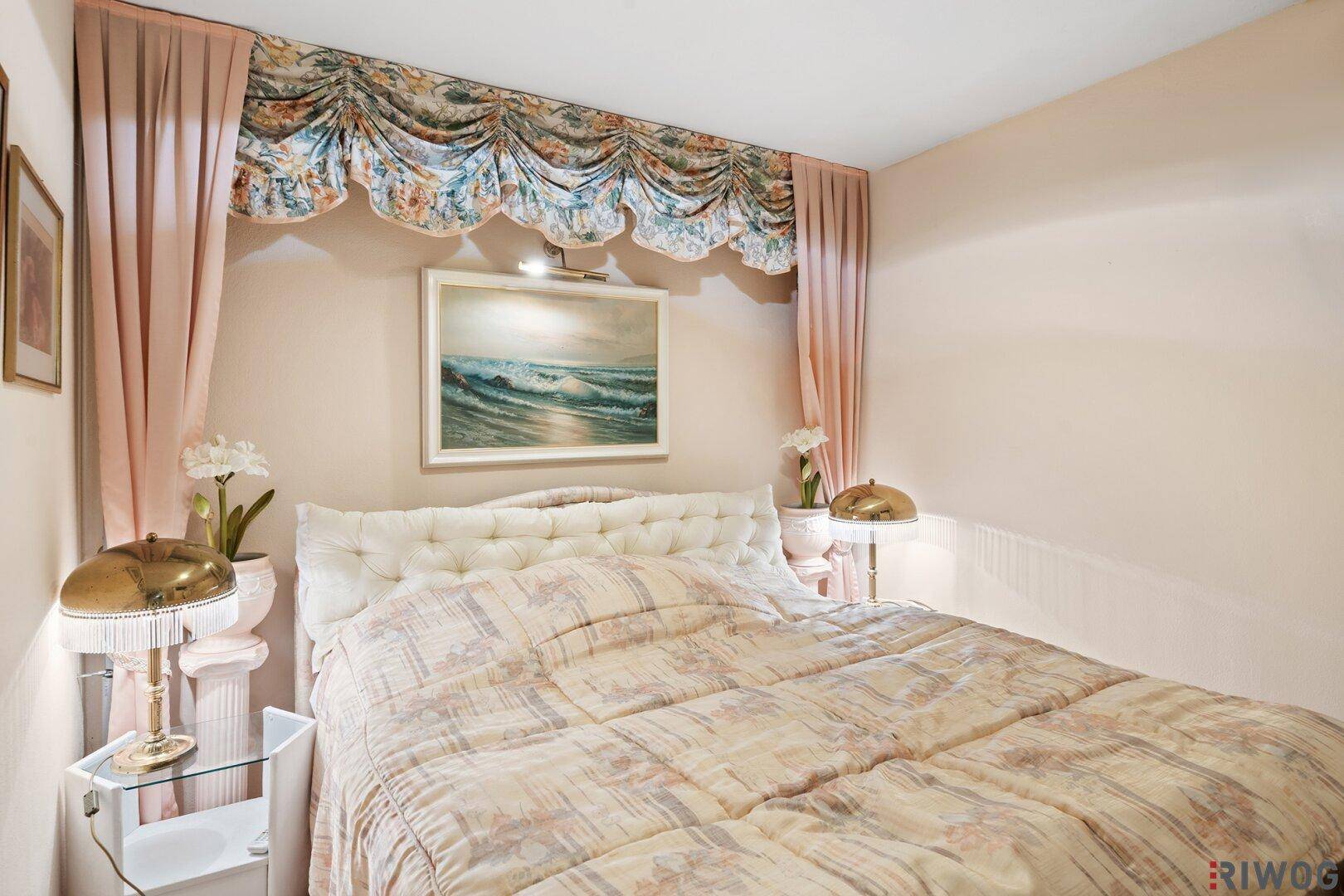 Gemütliches Schlafzimmer mit klassischer Dekoration, weichen Stoffen und indirekter Beleuchtung.