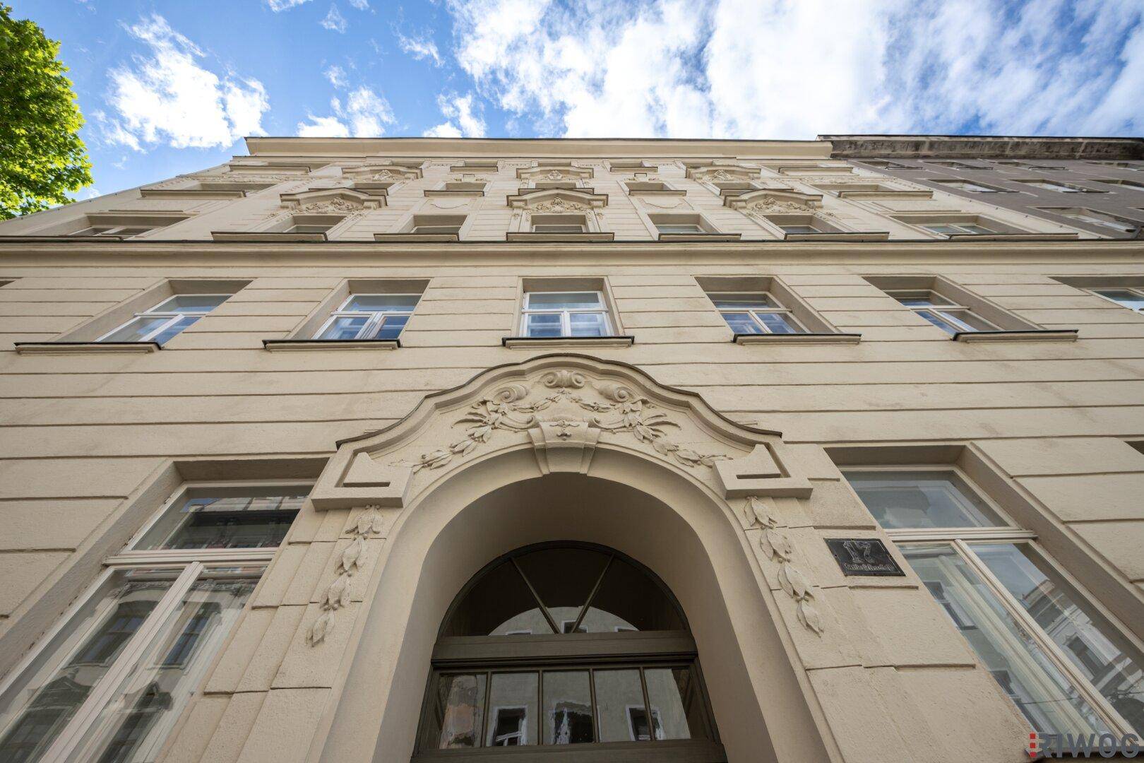 Beeindruckende Fassade eines Altbaus mit vielen Fenstern und architektonischen Verzierungen.