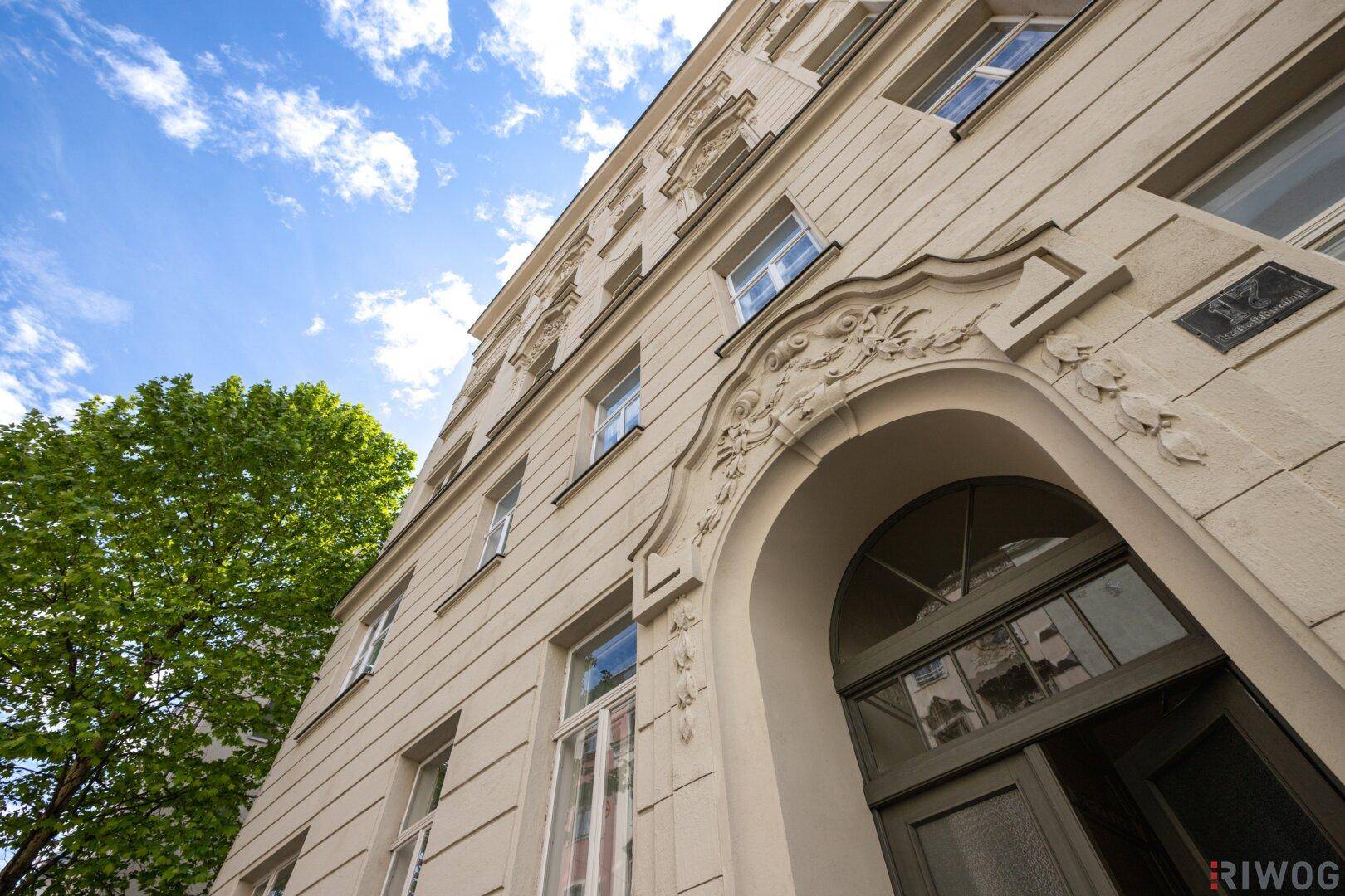 Historische Gebäudefassade eines Altbaus mit klassischer Architektur und hohen Fenstern.