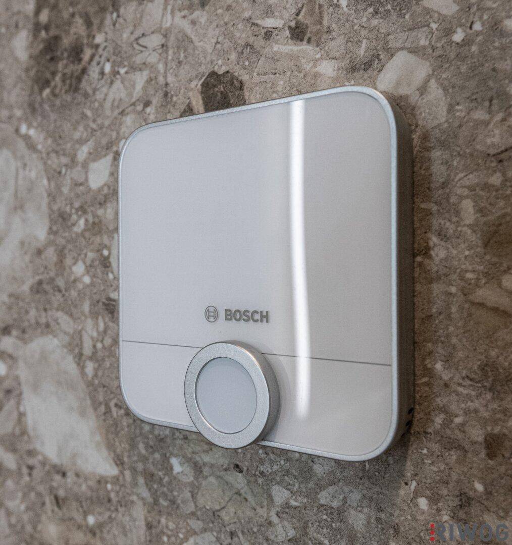 Bosch Smart-Home-Gerät an einer eleganten Wand mit Natursteinoptik-Fliesen.