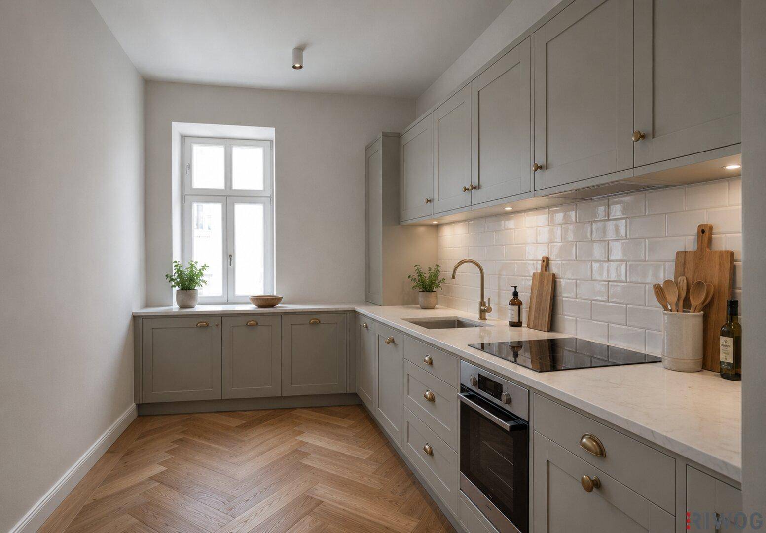 Moderne Küche mit grauen Schränken, Induktionskochfeld und Fischgrätparkett.