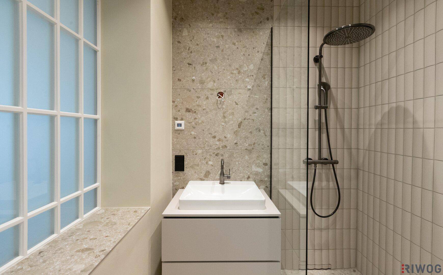 Modernes Badezimmer mit begehbarer Dusche, Regendusche und stilvollen Fliesen.