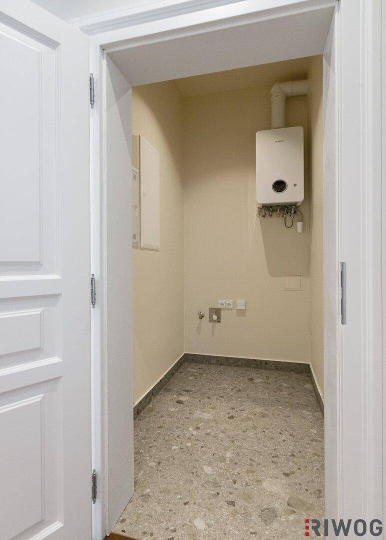 Praktischer Hauswirtschaftsraum mit Warmwasserbereiter und Anschlüssen für Geräte.