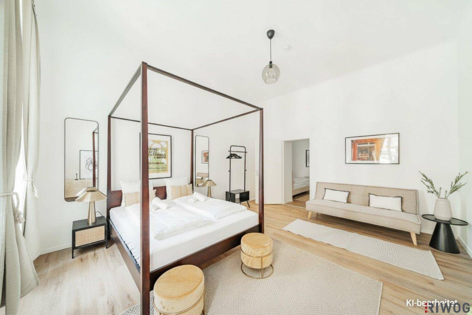 Helles Schlafzimmer mit Himmelbett, Holzboden und moderner Einrichtung.