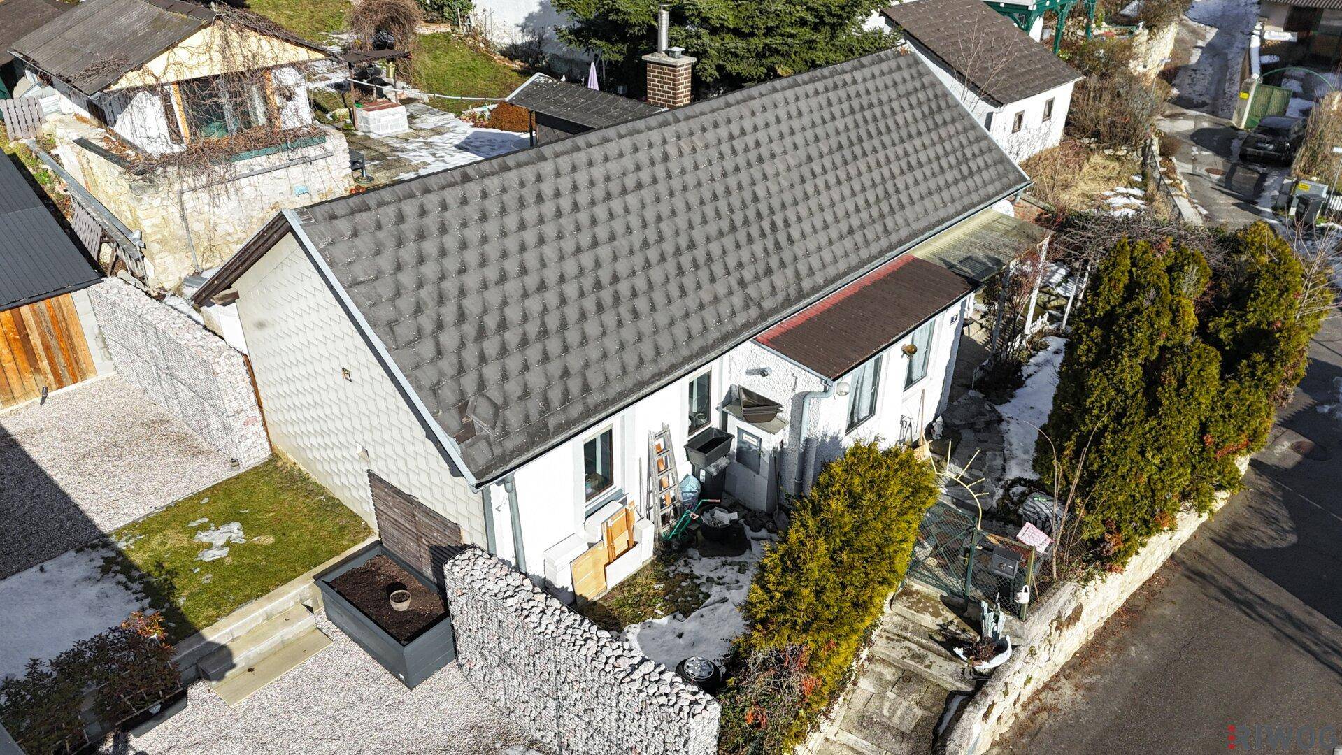 Luftaufnahme eines Einfamilienhauses mit Satteldach und gepflegtem Grundstück in ländlicher Umgebung.