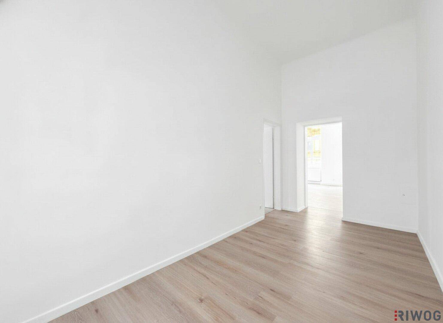 Heller Flur mit Holzboden und Zugang zu weiteren Räumen, ideal für offene Gestaltung.