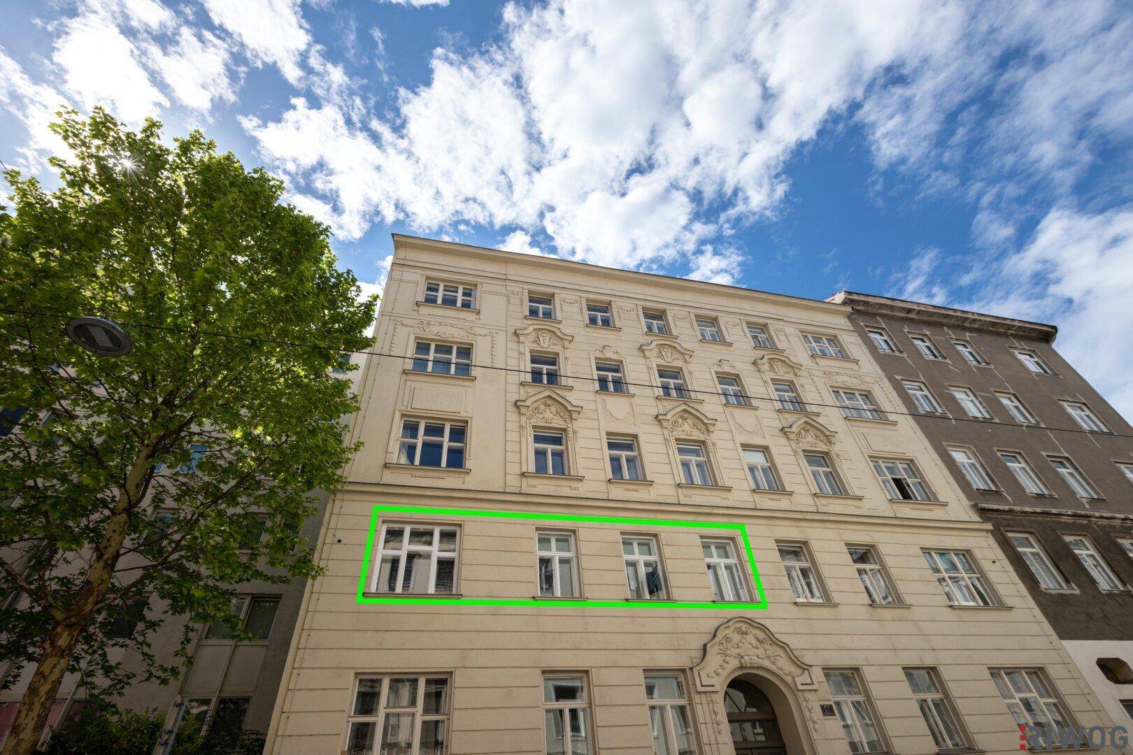 Fassade eines Altbaus mit hervorgehobenen Fenstern, die eine Wohneinheit markieren.