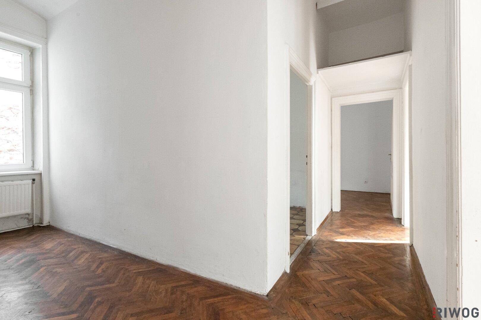 Heller Flur mit Fischgrätparkett und Zugang zu weiteren Zimmern, ideal für eine Altbauwohnung.