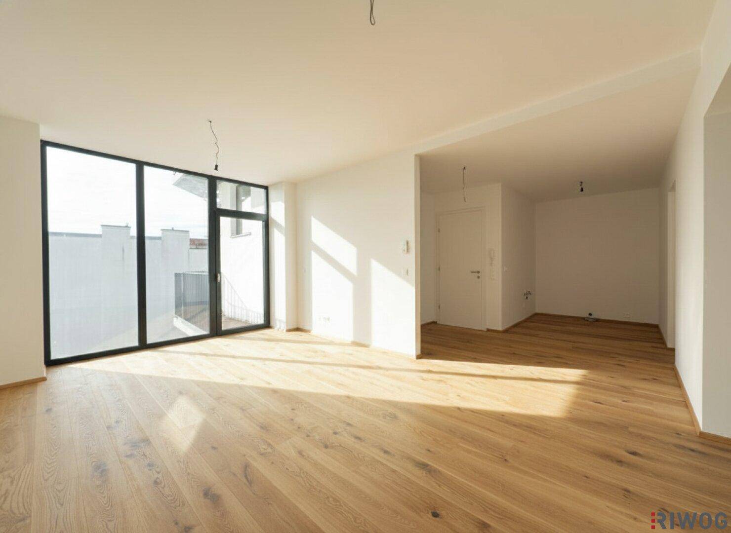 Sonnendurchfluteter Wohnbereich mit großen Fenstern, die viel natürliches Licht hereinlassen, und elegantem Holzparkett.