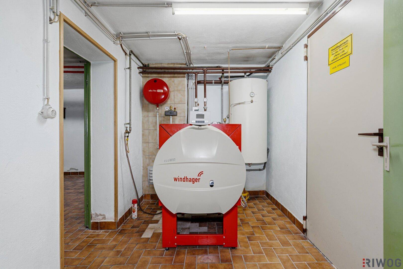 Heizungsraum im Keller mit einem großen Windhager-Boiler und weiterer Heizungstechnik.
