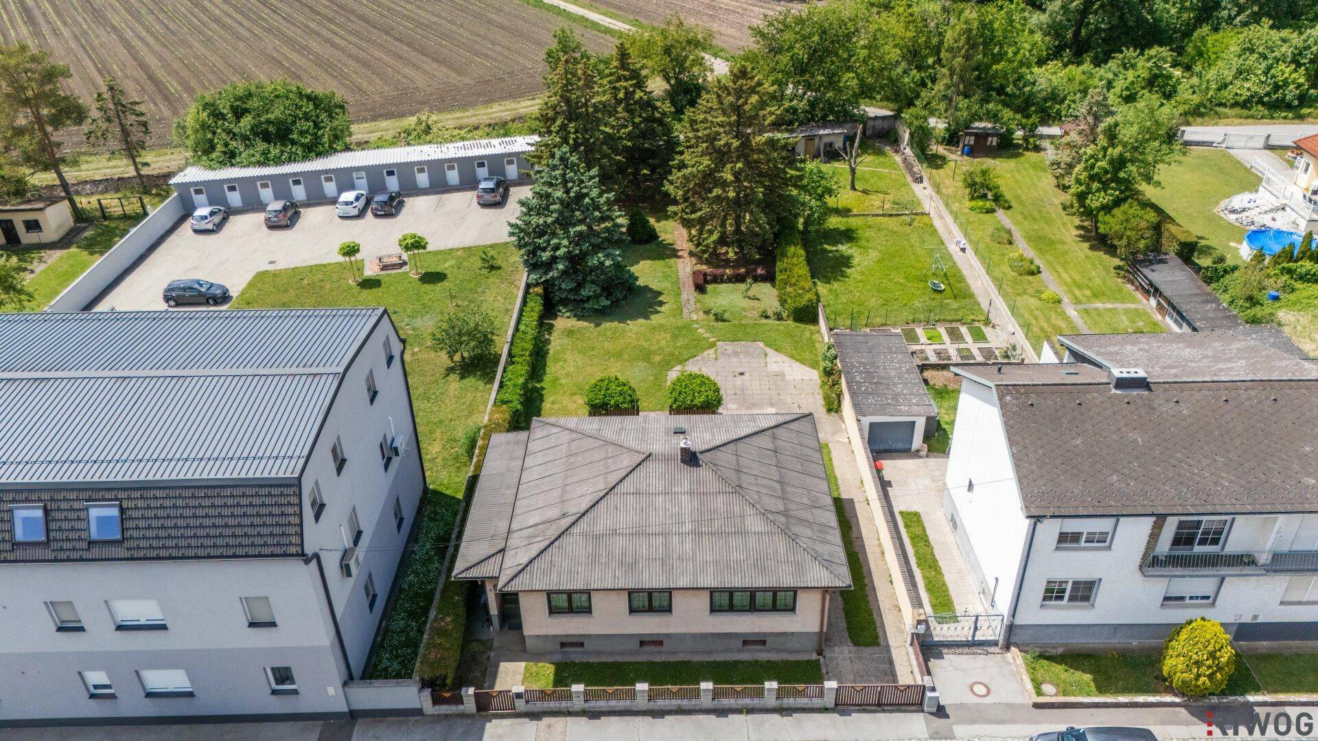 Weitläufige Luftaufnahme des Hauses mit großem Garten, angrenzenden Feldern und umliegenden Gebäuden.