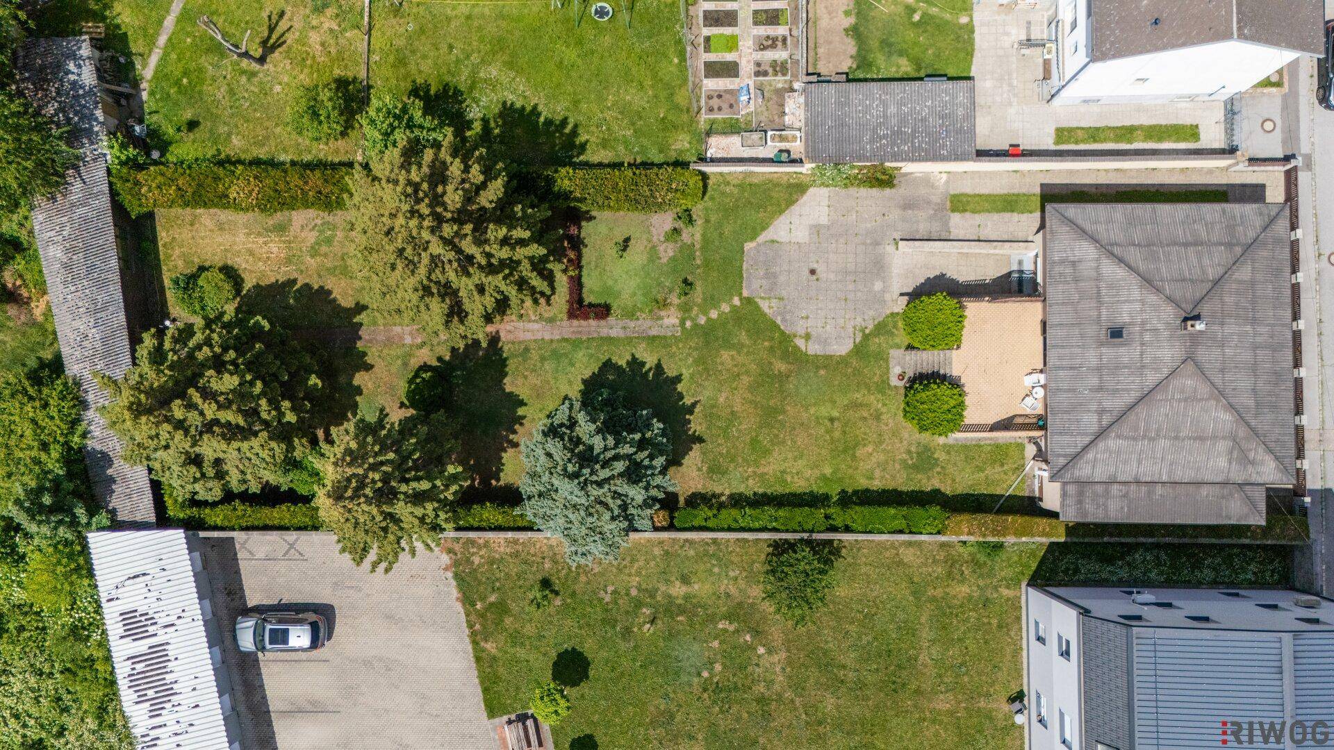 Vogelperspektive des Grundstücks mit Haus, großem Gartenbereich und angrenzenden Parzellen.