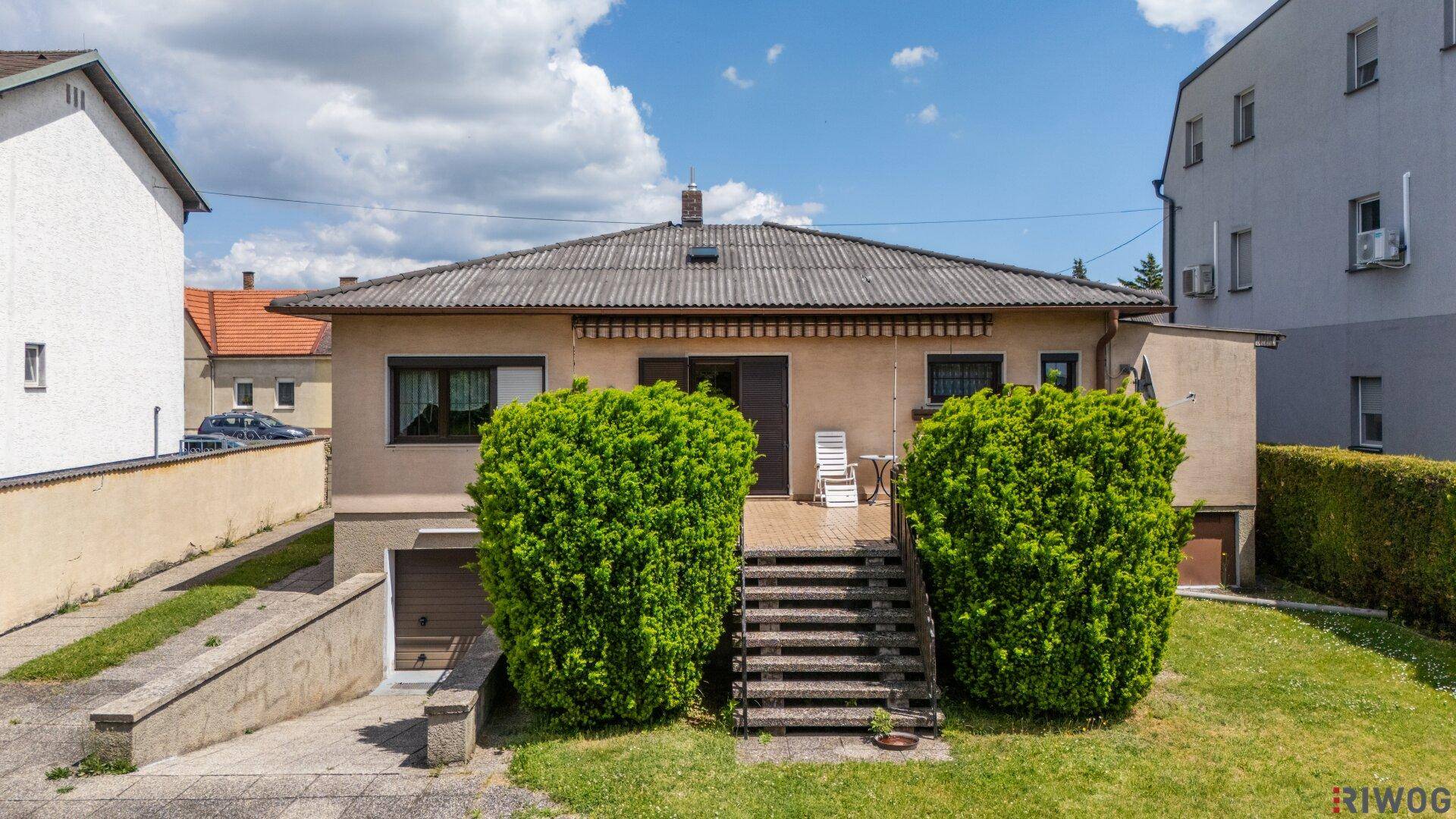 Rückseite des Hauses mit Außentreppe, kleiner Terrasse und Zugang zum Garten.