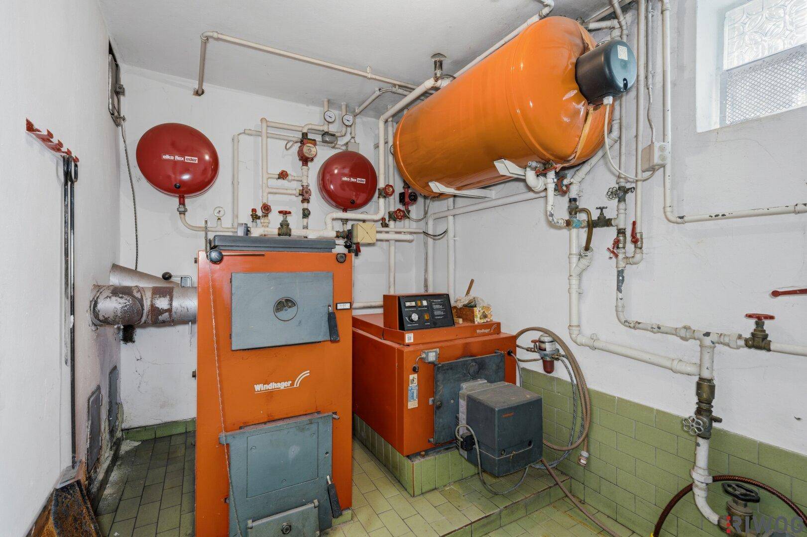 Heizungsraum im Keller mit zwei großen Heizkesseln und Warmwasserspeicher.